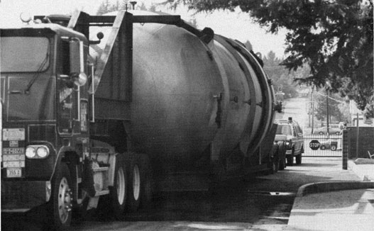 Large tank on a lowboy trailer entering the gate.