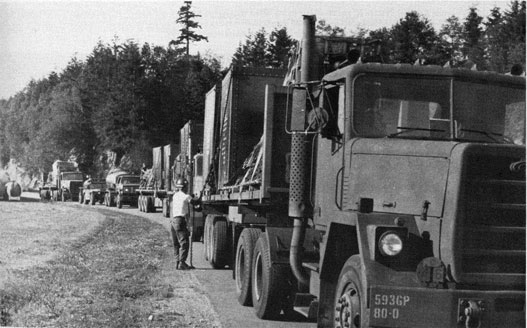 Long line of trucks stopped on a road.