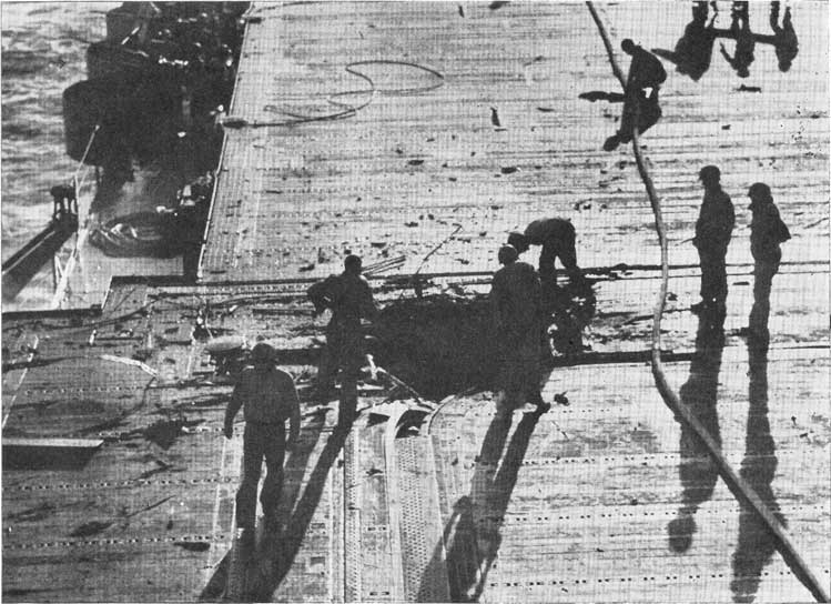 Figure 0-A. Bomb hole in the flight deck. Rapid covering of such holes is an important function of repair personnel.
