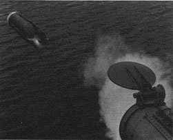 A torpedo is shown in flight after leaving a torpedo tube.