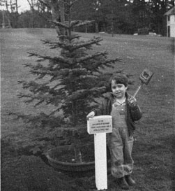 Small David Rossi with shovel in front of the tree.