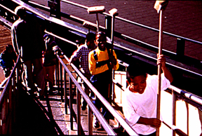 Crew walking up the gangway with cleaning tools.