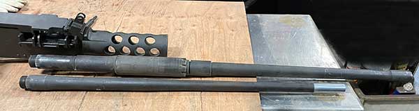 gun on left with two barrels on bench