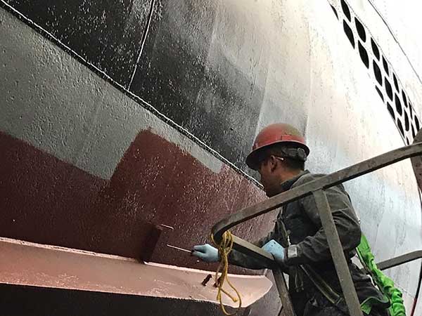 worker rolling anti-fouling paint.