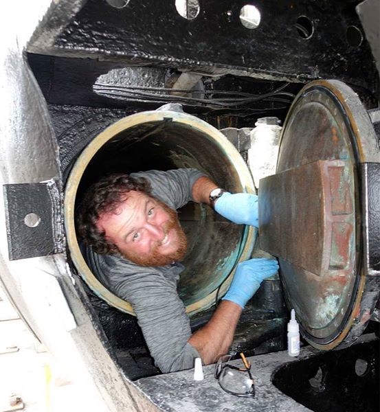 Photo of Craig Williams in the torpedo tube installing an extra, thin gasket.