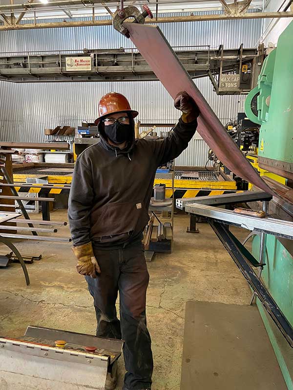 operator proudly standing by partially bent piece