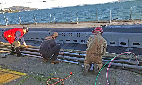 crew measuring up conduit extension aft on the pier