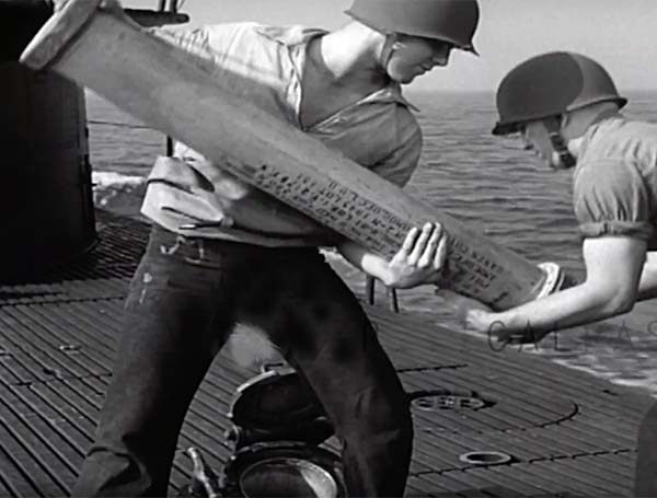 photo of sailor removing service round from cartridge tank