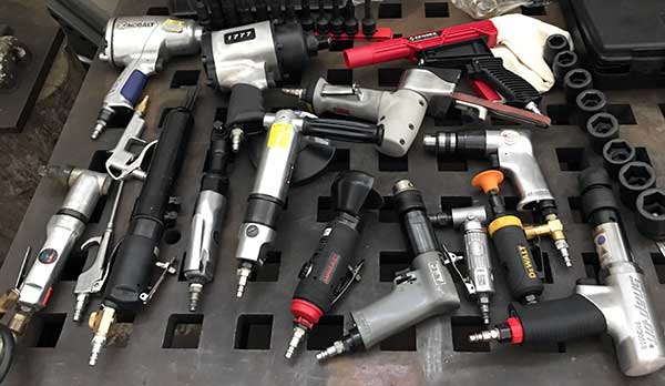 large collection of air tools spread on the welding table